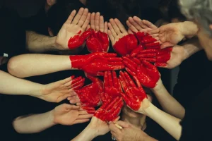 Hands Formed Together with Red Paint